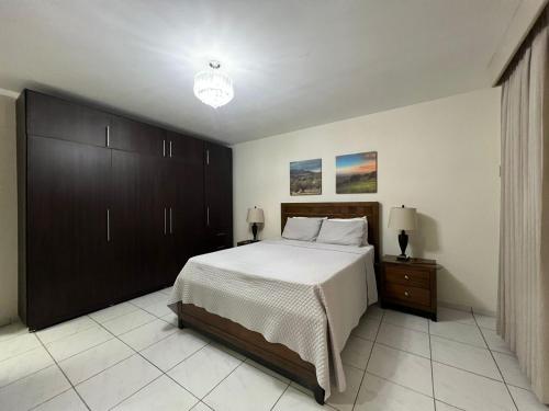a bedroom with a large bed and a nightstand at Hotel Casa Pamplona in San Salvador