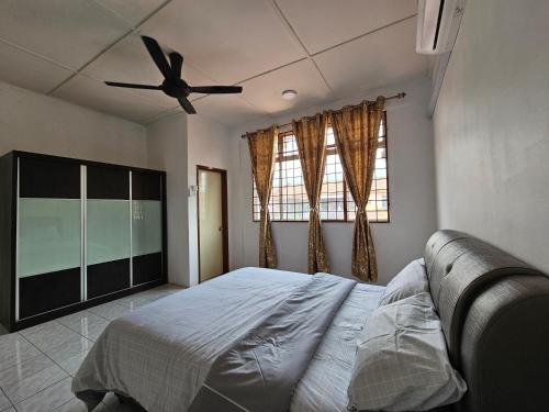 a bedroom with a bed and a ceiling fan at Sapphire Residence in Jenjarum