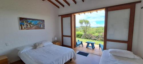 a bedroom with a bed and a large window at Finca Buena Vista in Guatapé