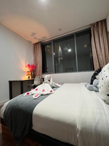 a bedroom with a bed with stuffed animals on it at Summer Suite KLCC By Citybox in Kuala Lumpur