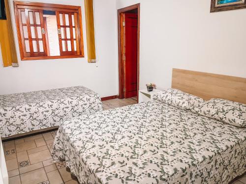 1 dormitorio con 2 camas y ventana en Pousada Estância Mineira en Guapé