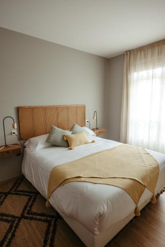a bedroom with a large white bed with a window at LAR DA REVOLTA in Cedeira