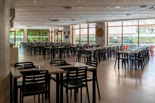 a dining room with tables and chairs and windows at Intelier Orange in Benicàssim