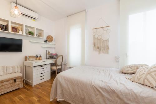 Habitación blanca con cama y escritorio en Via Augusta, en Barcelona