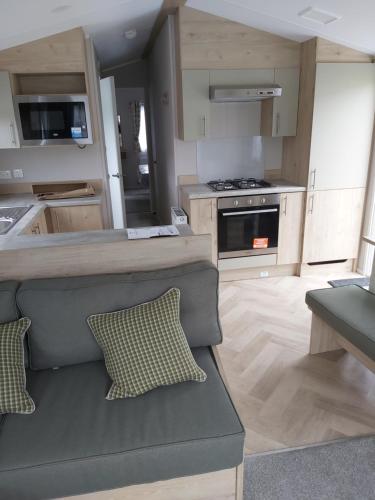 a kitchen with a couch in the middle of it at Wood Farm Holiday Park in Charmouth