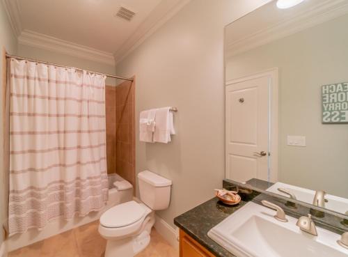 a bathroom with a toilet and a sink and a mirror at Inlet Blue Home in Inlet Beach