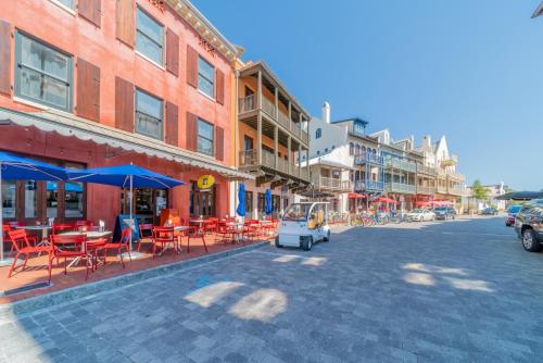 a street with tables and chairs and a food cart at Inlet Blue Home in Inlet Beach