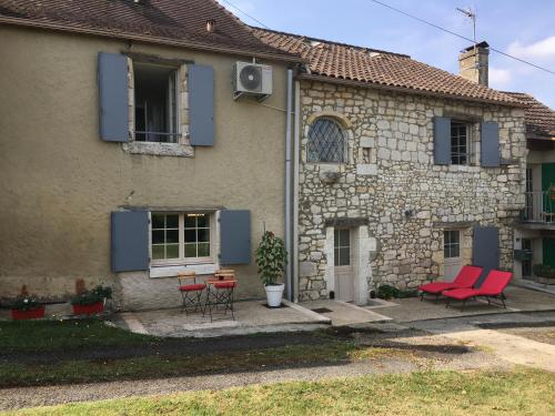 une maison avec des chaises rouges et une table devant elle dans l'établissement Clos PIMI, à Monbazillac