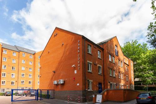 an orange brick building in front of a building at For Students Only - Park Court in Lincoln in Lincoln