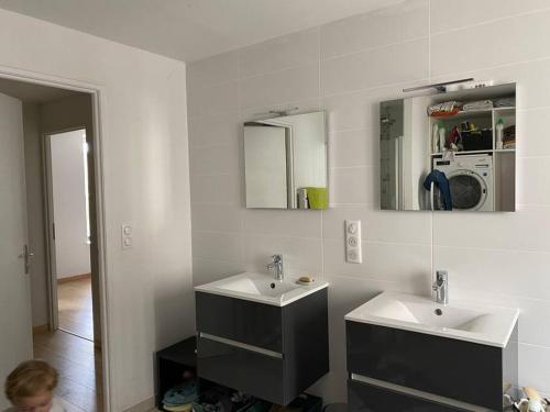 een badkamer met twee wastafels en twee spiegels bij La maison Familiale in Dijon