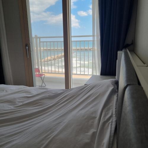 a bedroom with a bed and a view of the ocean at Yangyang Ocean Stay 환상적 전면 오션뷰 in Yangyang