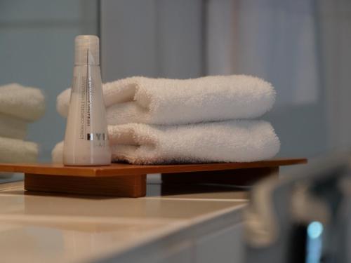 a stack of towels and a hair dryer on a shelf at Privathotel Bremer in Bergisch Gladbach