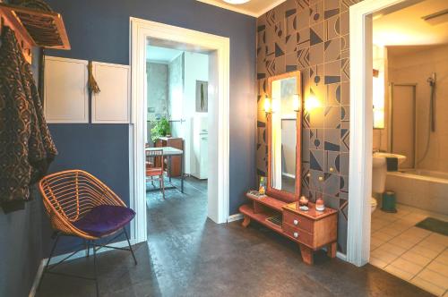 y baño con espejo, silla y mesa. en Ferienwohnung Feel Good Apartment - zentrale 65qm Design Fewo im Zittauer Gebirge - bahnhofsnah in ruhiger Lage, en Zittau