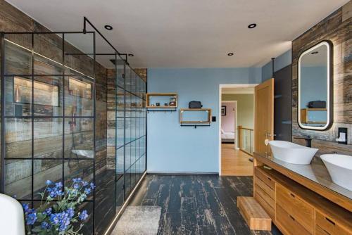 a bathroom with two sinks and a glass wall at Sycamores - Fabulous family home with huge garden in Kent