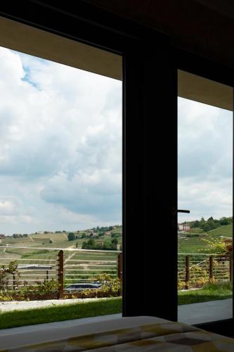 a window view of a field from a bedroom at Casa Nicolini in Barbaresco