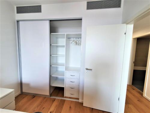 a closet with white cabinets and a glass door at Prestigious SKY PARK apartment - top city view - Traveller awards 2024 in Bratislava