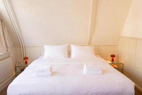 a bedroom with two beds with white sheets at hotel calisto in Amsterdam