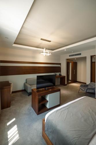a hotel room with a bed and a couch at Hotel Prishtina in Pristina