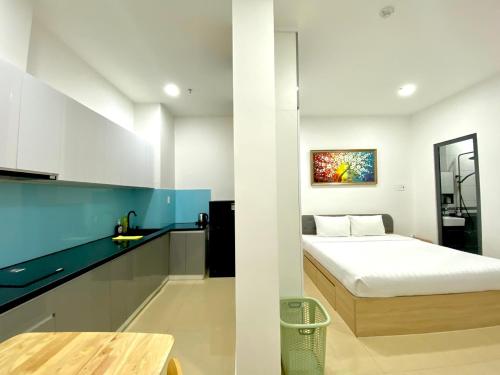 um pequeno quarto com uma cama e uma cozinha em Chanh Huy Apartments & Hotel em Ho Chi Minh