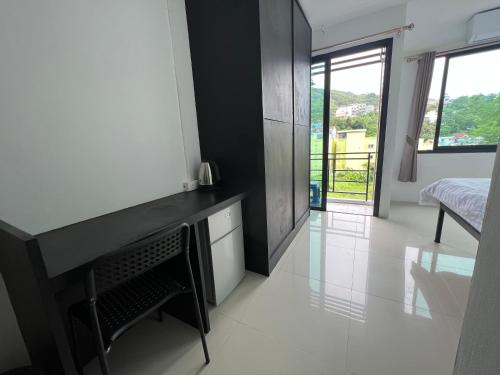 a room with a desk and a bedroom with a bed at Patong Easy Life 6 in Patong Beach