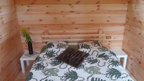 Cama en habitación con pared de madera en Camping Fluffy Horns - Kempings Pūkainie Ragi, en Plieņciems
