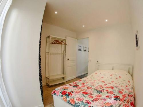 um quarto com uma cama com colcha floral em Appartement à 30 minutes de Disney et de Paris em Fontenay-sous-Bois