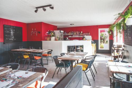 een restaurant met tafels en stoelen en rode muren bij Camping Landudec in Landudec