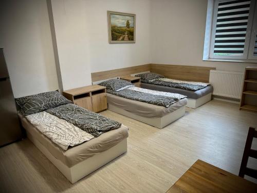 Pokój z 3 łóżkami i kanapą w obiekcie Hostel Sportowa w mieście Płońsk