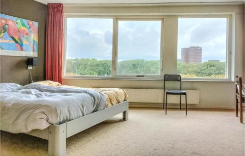a bedroom with a bed and a window and a chair at 3 Bedroom Stunning Home In Vlissingen in Vlissingen