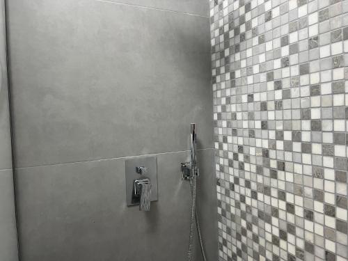 e bagno con doccia e parete piastrellata. di Pretty Home Kaonet a Orikum