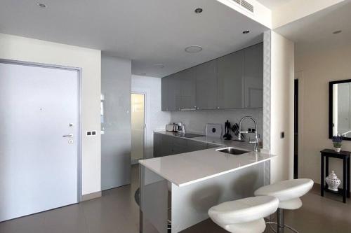 a kitchen with a counter and two stools at Luxury apartment Residencial Sunset Drive - Benidorm, España in Benidorm