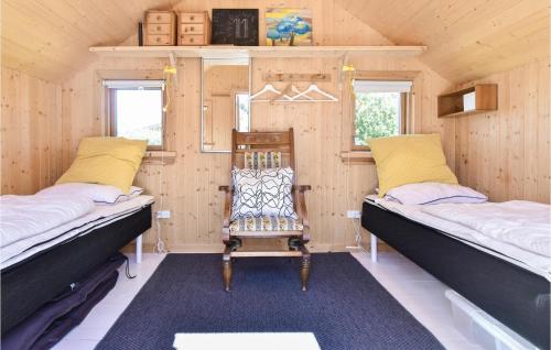 カーテミンドにあるStunning Home In Kerteminde With 3 Bedrooms And Wifiのベッド2台と椅子が備わる客室です。