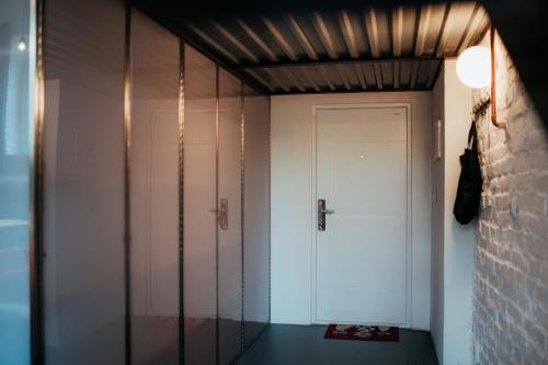 korytarz z białymi drzwiami i szklaną ścianą w obiekcie Smaltovňa Loft D w Łuczeńcu