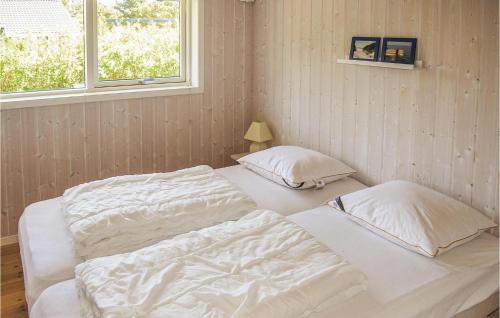 two twin beds in a room with a window at Holiday Home Enebærvænget Humble Ii in Nyby
