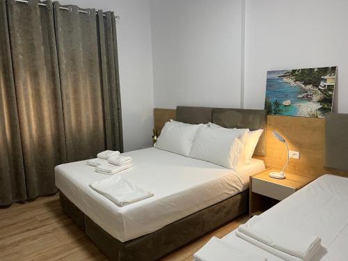 una piccola camera da letto con un letto con lenzuola bianche di Pretty Home Kaonet a Orikum