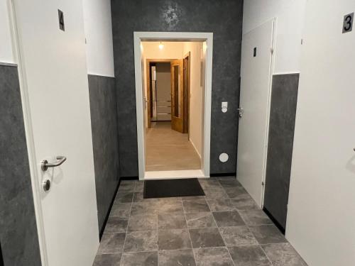 a hallway with a hallway leading into a room with a mirror at Golden Gate Orth an der Donau in Orth an der Donau