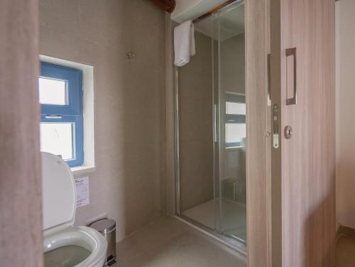 a bathroom with a toilet and a glass shower at Phaedrus Living: Peristerona Traditional Maisonette in Peristerona