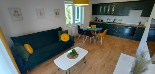 a living room with a green couch and a table at Allewidok 2 in Jelenia Góra