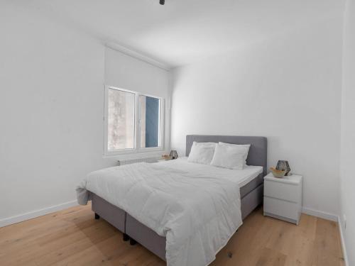 um quarto branco com uma cama grande e uma janela em A Ruzettelaan 39 3 bedrooms on floor 2 em Blankenberge