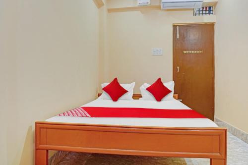 a bed with red pillows in a room at OYO Flagship Shree Hotel New Rajdhani in Patna