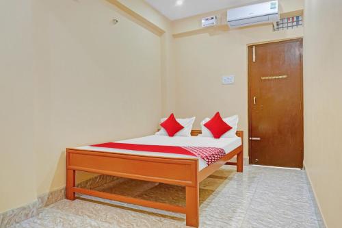 a bedroom with a bed with red pillows on it at OYO Flagship Shree Hotel New Rajdhani in Patna