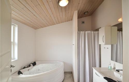 een badkamer met een bad en een wastafel bij Amazing Home In rsted With Kitchen in Ørsted