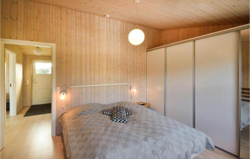 een slaapkamer met een bed in een kamer met houten wanden bij Amazing Home In rsted With Kitchen in Ørsted