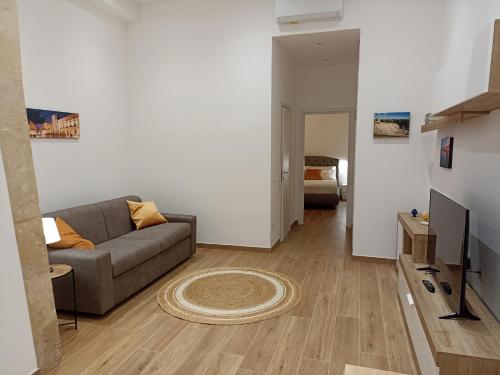 een woonkamer met een bank en een televisie bij Appartamento Aretusa di G&G in Siracusa