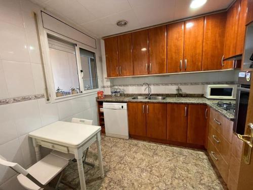 - une cuisine avec des placards en bois, une table et un évier dans l'établissement Olive’s Montseny, à Breda
