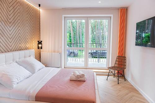 a bedroom with a large white bed and a window at Apartament Villa Rubin in Borne Sulinowo