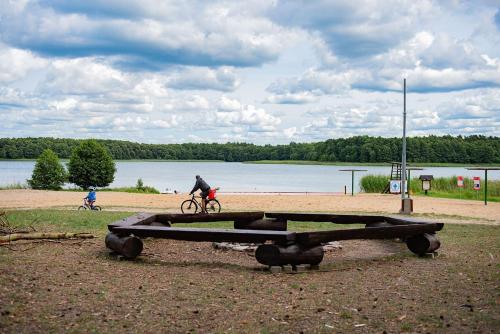 a man riding a bike next to a picnic table at Apartament Villa Rubin in Borne Sulinowo