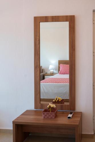 a bedroom with a mirror and a wooden table at Star Beach apartment in Kastrí