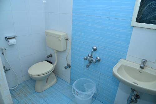 a bathroom with a toilet and a sink at Hotel V M Comfort in Bangalore