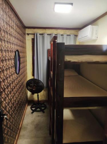 a small room with two bunk beds and a chair at Sanctuary Pirenópolis Suítes e Flats in Pirenópolis